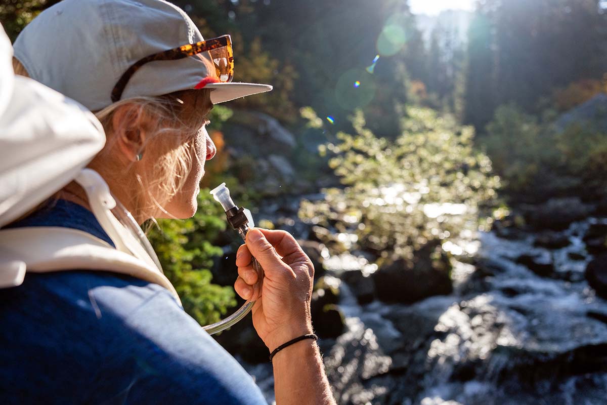 Drinking from hydration bladder (stream in background)